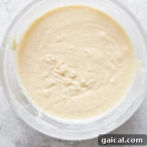 Golden Pineapple Flips 12 Top view of a glass bowl containing freshly prepared, smooth bread dough on a white surface.