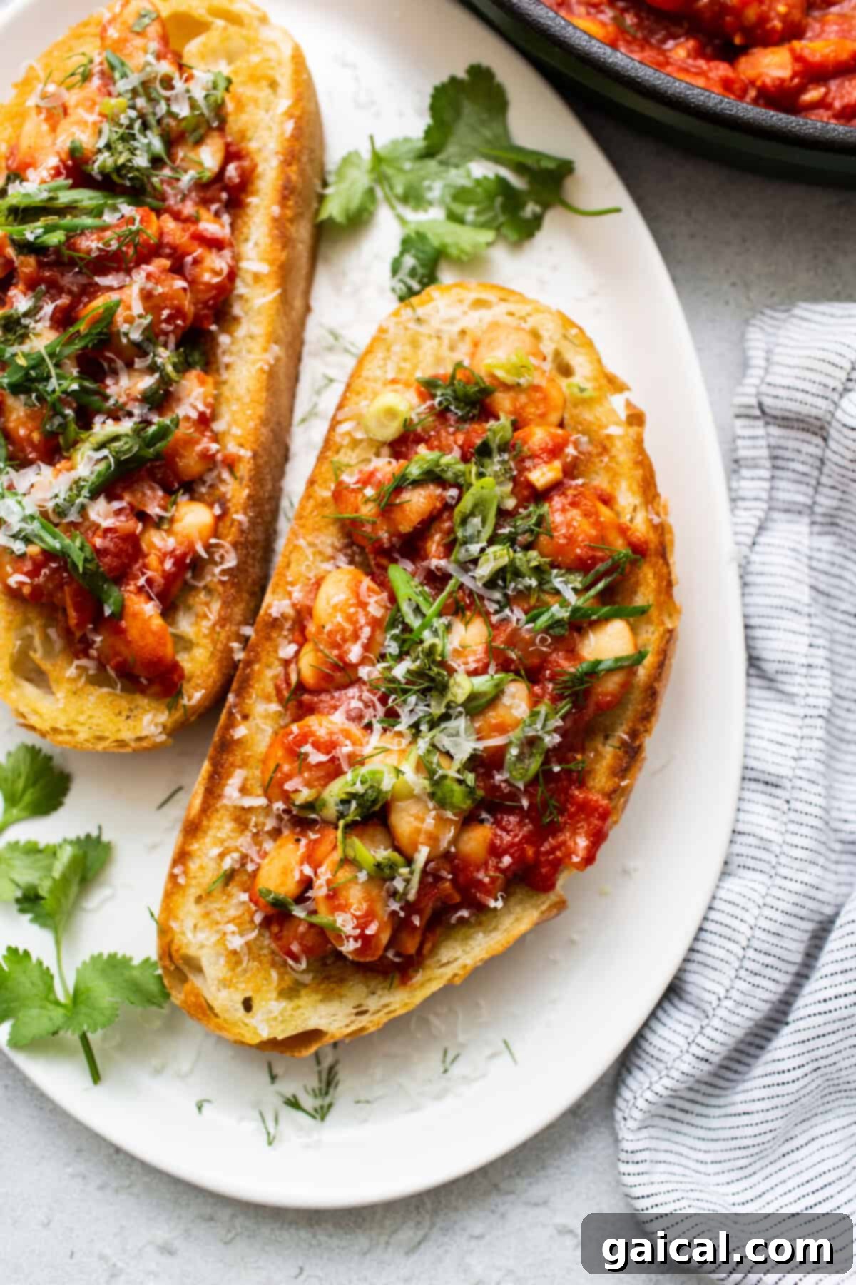 Two slices of golden brown toast, perfectly crisp, topped with a vibrant green garnish, ready to be served as part of a meal.
