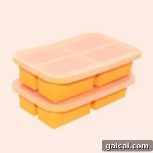 A stack of orange ice cube trays on a beige background.