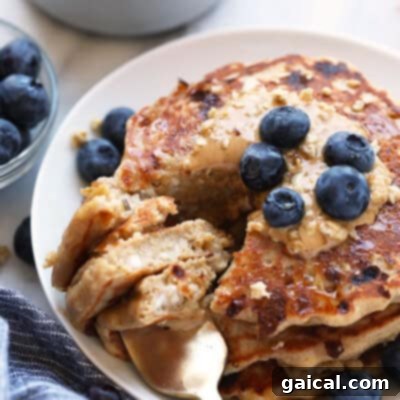 Protein-packed oatmeal pancakes with blueberries on a plate.