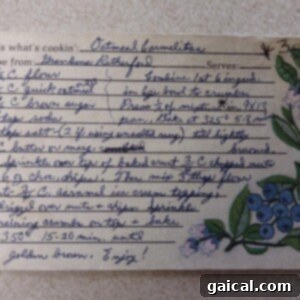 Nana Mabels Carmelita Bars 3 A beautiful, ornate handwritten recipe card specifically for Carmelita bars. The card includes detailed step-by-step instructions and is adorned with a charming blue floral illustration on the right side, giving it a vintage, personal touch.