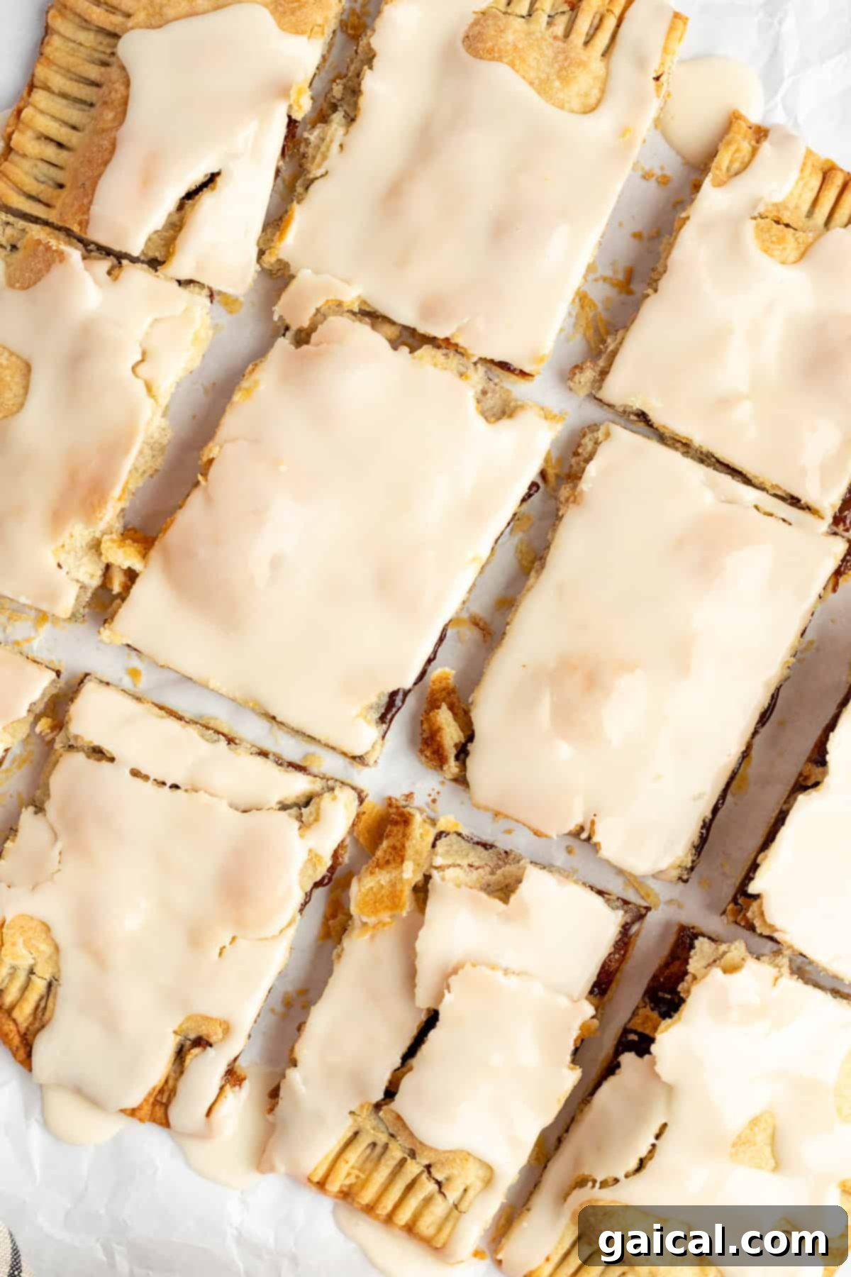 Fueling Frosted Pastries 2 A grid of homemade frosted Protein Pop Tarts with a light beige icing, arranged neatly on parchment paper.