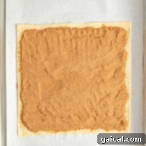 Fueling Frosted Pastries 11 Rectangular dough on parchment paper with a layer of brown sugar filling spread evenly on top.