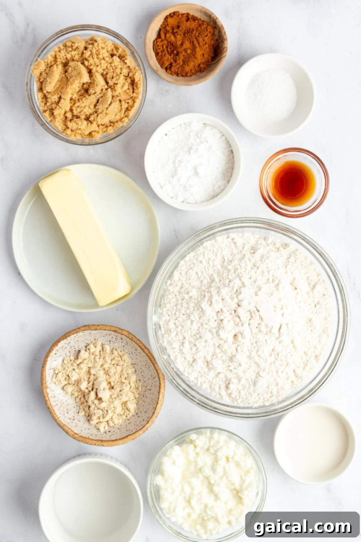 Fueling Frosted Pastries 4 A collection of baking ingredients including flour, brown sugar, butter, and liquids in bowls and plates.