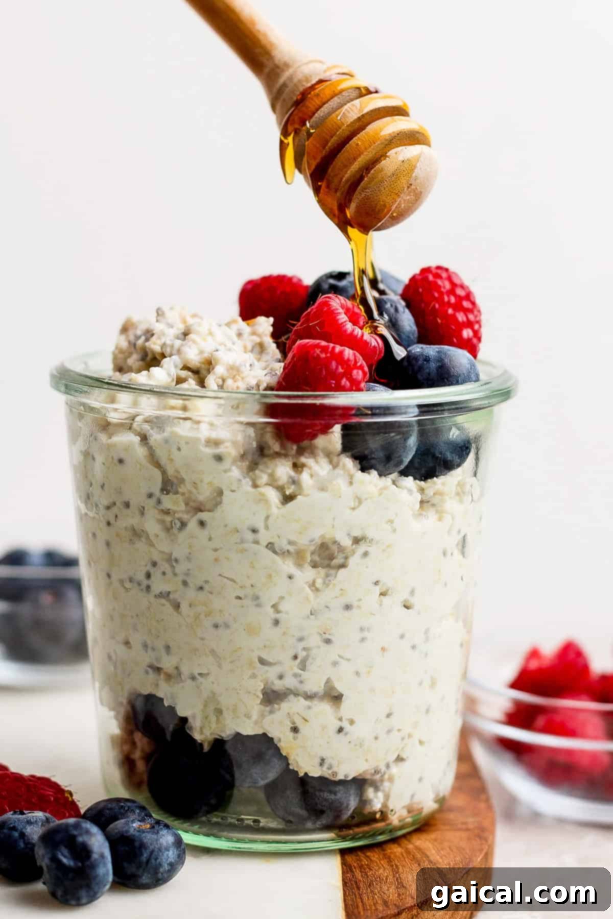 A beautifully presented jar of creamy Cottage Cheese Protein Overnight Oats, garnished with fresh berries and a drizzle of honey.