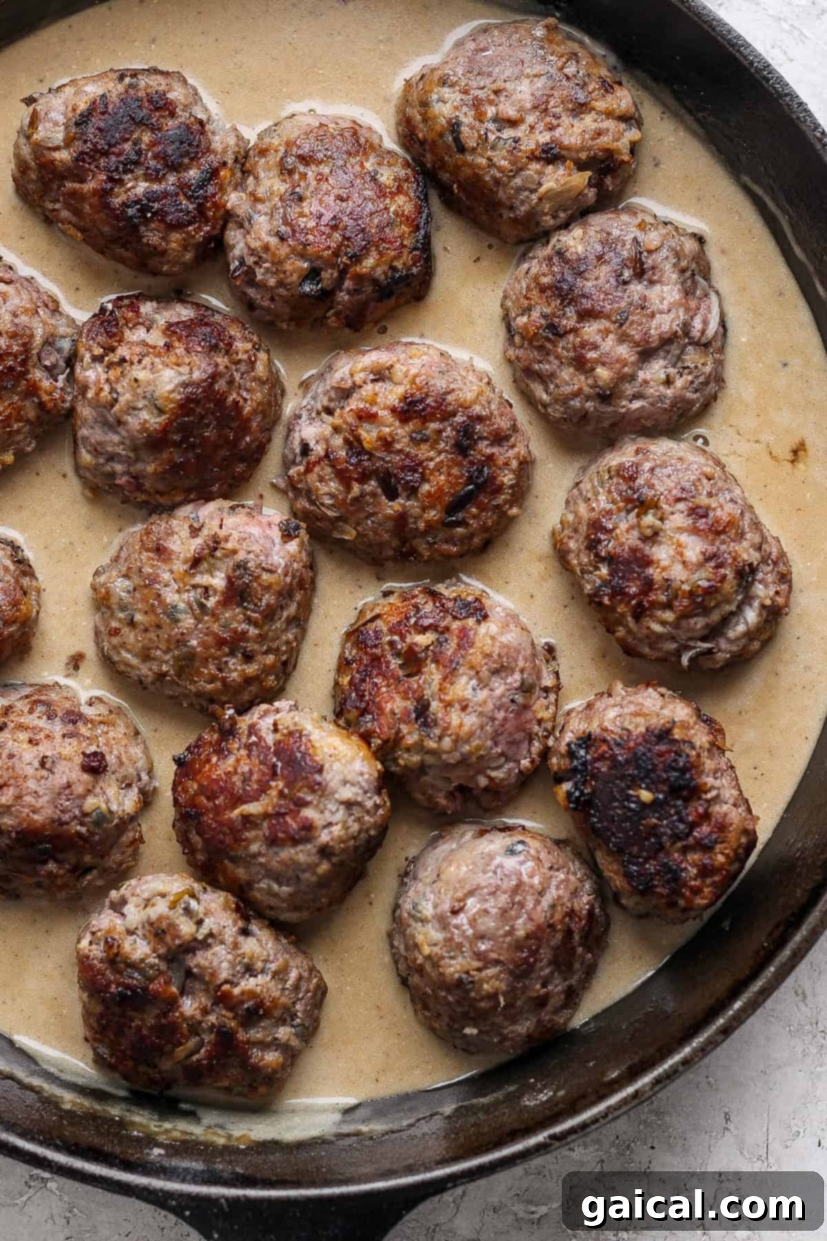 North Star State Swedish Meatballs 5 A cast-iron skillet filled with perfectly browned Minnesota Swedish Meatballs simmering in a rich, creamy gravy.