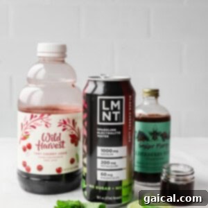 Nighttime Nectar 8 A bottle of tart cherry juice, a can of LMNT electrolyte drink, elderberry syrup, mint leaves, and lime slices on a white surface.