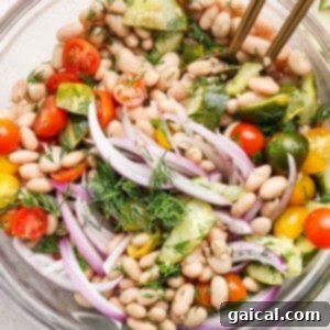 Zesty Dill Pickle White Bean Salad 6 Bowl of white bean salad with cherry tomatoes, cucumber, red onion, and dill.