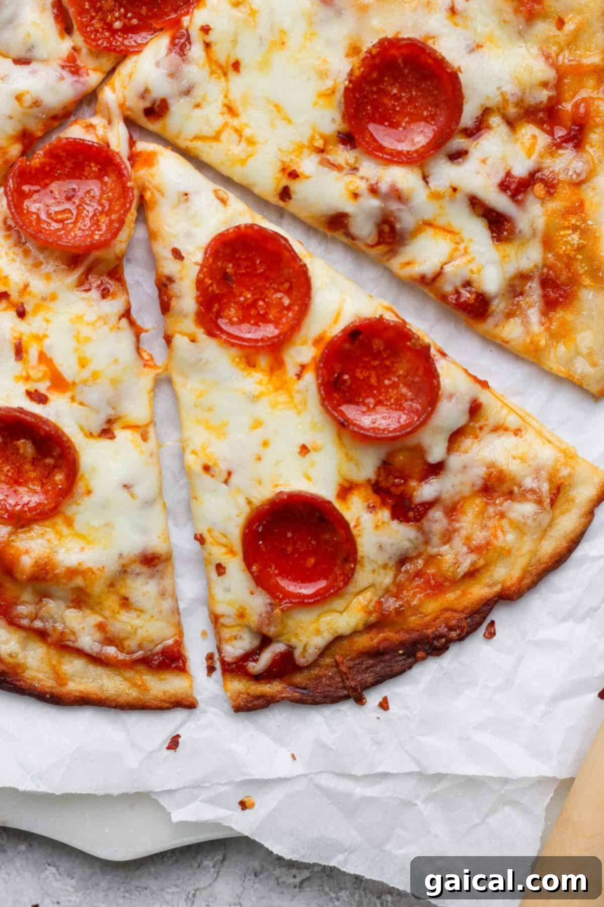 Rapid Four Ingredient Protein Pizza Crust 2 Slices of pepperoni pizza with melted cheese on parchment paper.