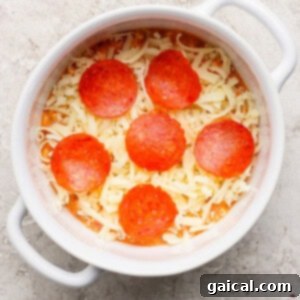Personal Cottage Cheese Pizza Bowl 5 A round white dish containing shredded cheese and six slices of pepperoni on a textured surface.