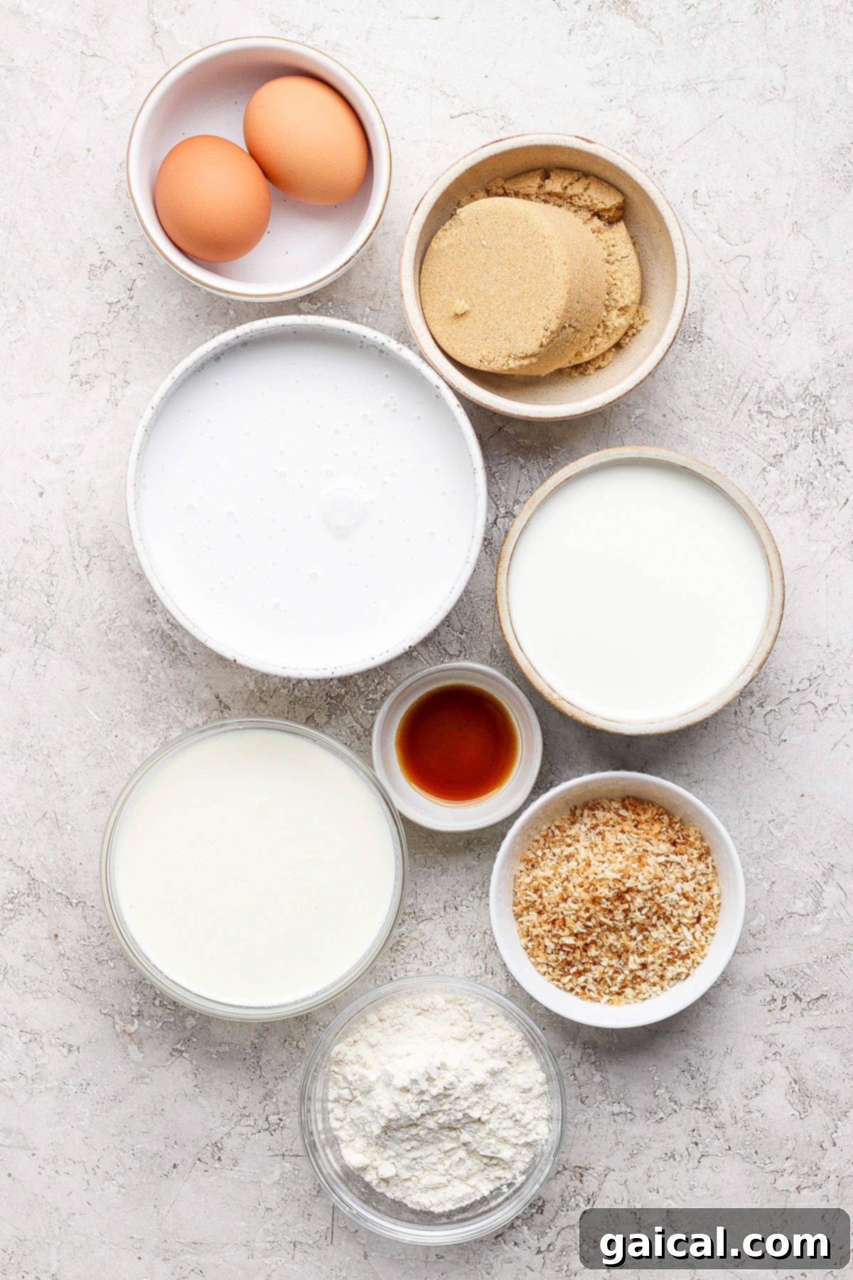Luscious Coconut Cream Pie 3 Assorted baking ingredients including fresh eggs, golden brown sugar, white all-purpose flour, fragrant vanilla extract, shredded coconut flakes, and creamy milk, neatly arranged on a bright, minimalist surface, ready for baking.