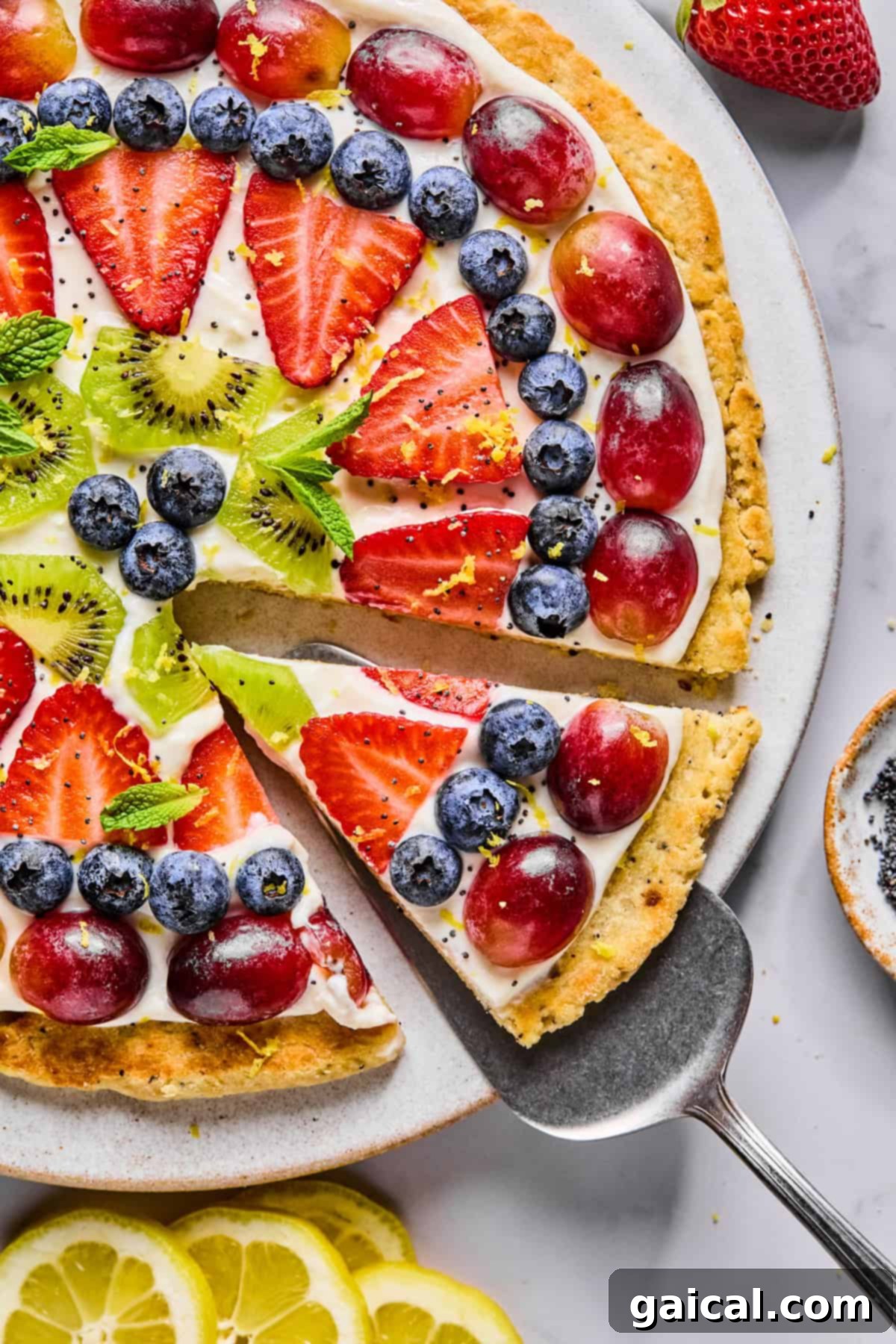 Protein-Packed Cottage Cheese Fruit Pizza 2 A vibrant fruit pizza topped with glistening sliced strawberries, kiwi, juicy blueberries, and plump red grapes, arranged beautifully on a creamy white layer. One slice is being gently lifted from the whole pizza, revealing the golden crust underneath.