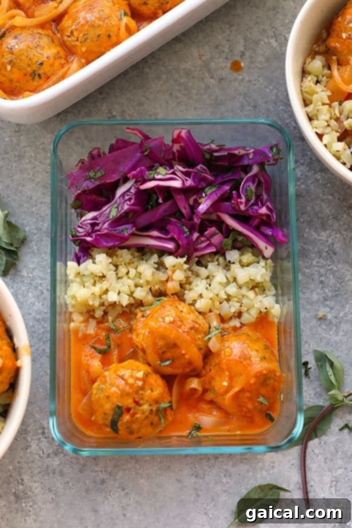 Prepared Red Coconut Curry Meatballs and cauliflower rice in a meal prep container, ready for the week