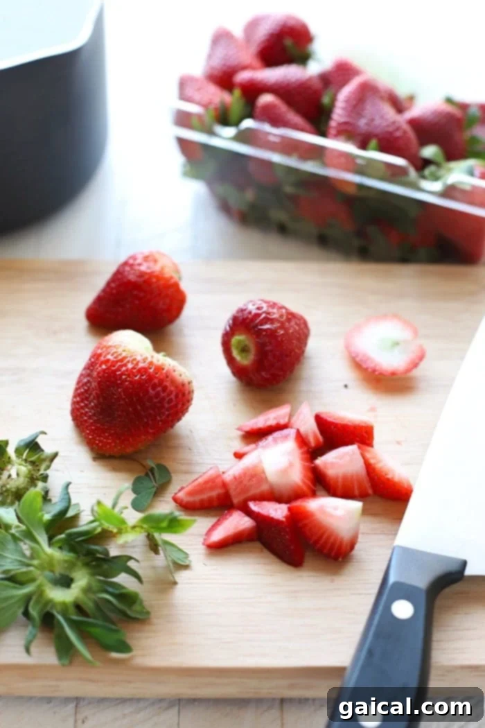 Fresh Strawberries for Homemade Compote Fresh, vibrant strawberries on a rustic wooden cutting board, ready for making compote.