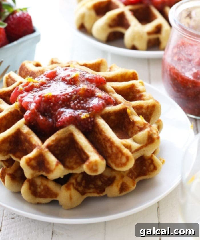 Paleo Waffles with Fresh Berries Stack of golden paleo waffles with fresh berries and maple syrup, ready to be served.