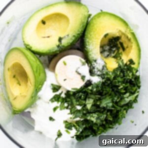 Avocado crema ingredients being blended in a food processor, creating a smooth and creamy topping.