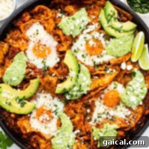 A close-up of a skillet filled with freshly made chilaquiles and baked eggs, ready to be served.