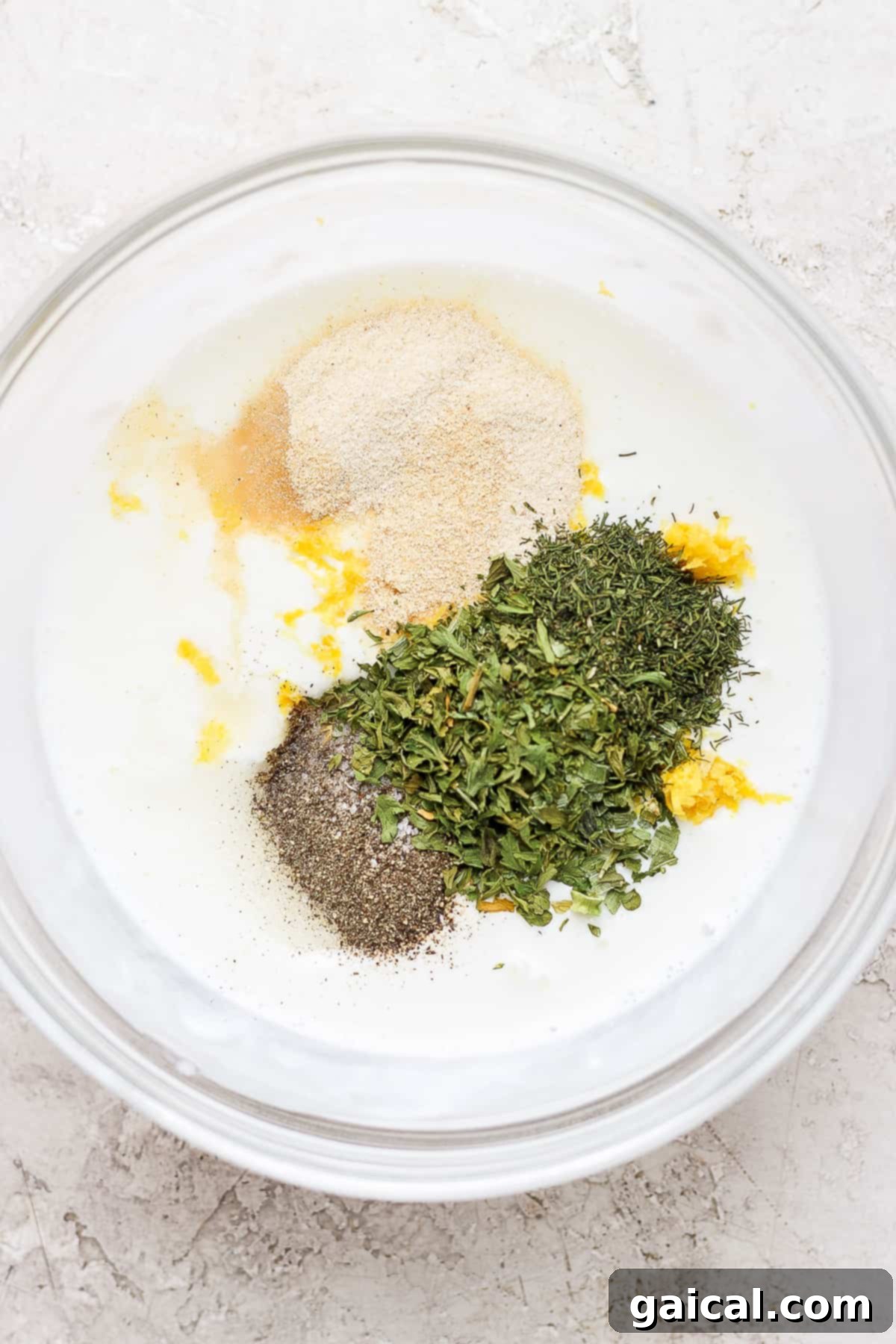 Ranch dressing ingredients combined in a bowl. All the ranch ingredients gathered in a mixing bowl before whisking.
