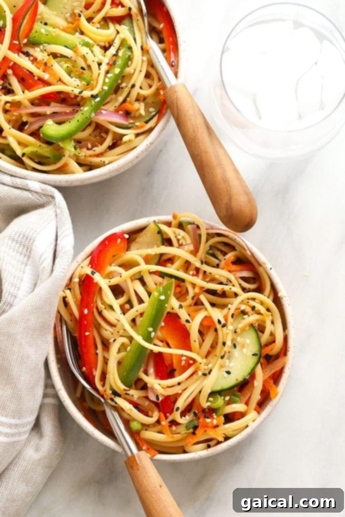 A close-up shot of a cold Asian noodle salad in a bowl, highlighting the texture of the noodles and the freshness of the sliced vegetables.