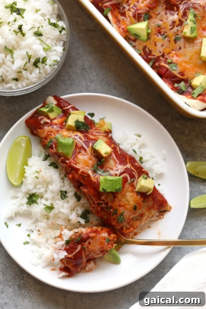 Delicious Healthy Chicken Enchiladas with Sweet Potatoes Healthy chicken enchiladas served on a white plate, topped with fresh avocado and cilantro.