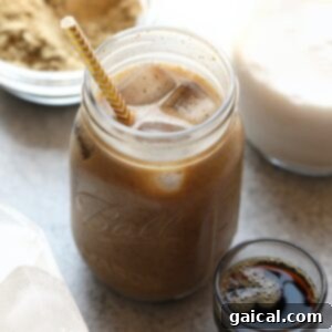 A protein drink in a mason jar filled with cold brew coffee and a straw, ready to be enjoyed.