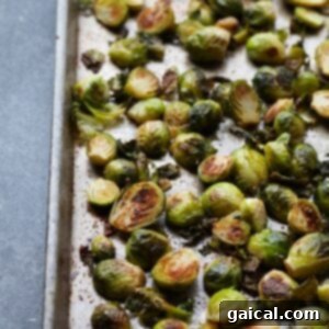 Roasted brussels sprouts with parmesan on a baking sheet.