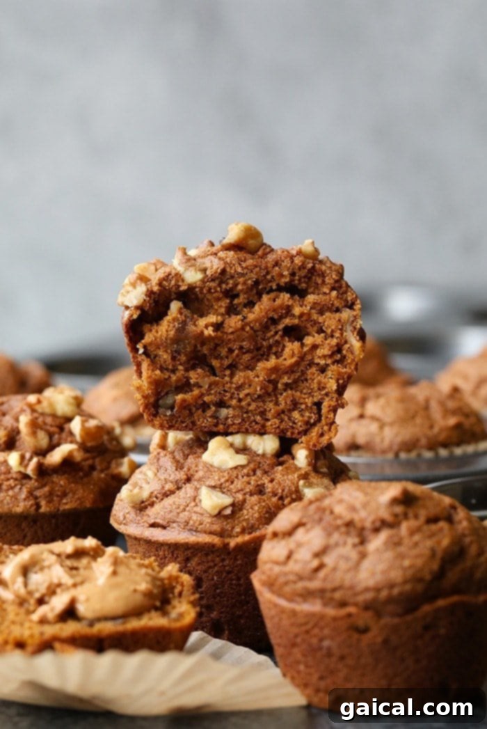 Nutritious Pumpkin Spice Muffins 6 A perfectly stacked pile of golden brown healthy pumpkin muffins, ready to be savored, highlighting their perfect texture.