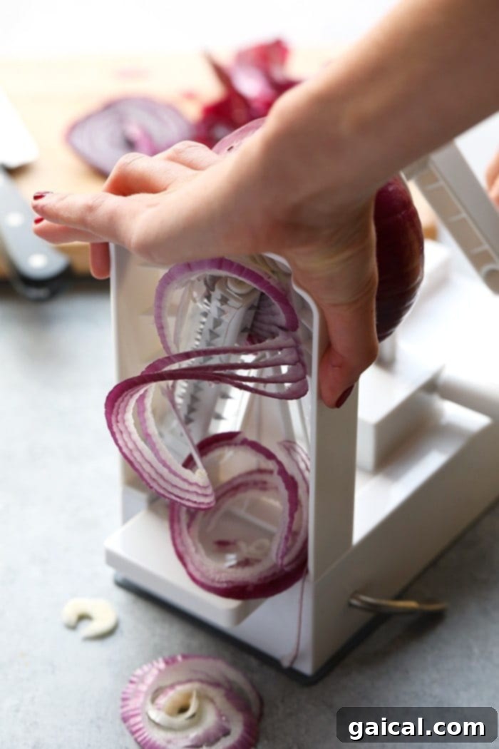 Close-up of thinly sliced red onions, perfectly prepped for caramelization.