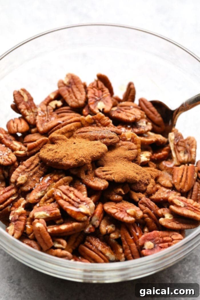 Maple roasted pecans with cinnamon in a mixing bowl.