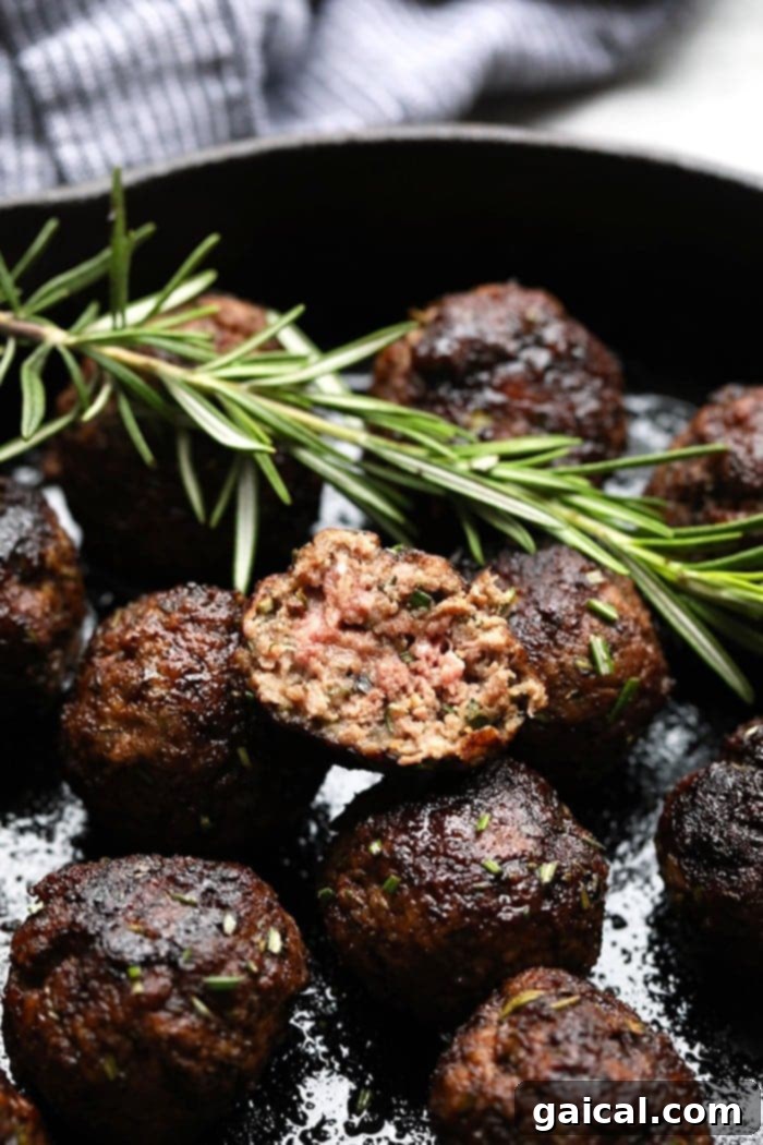 Tender balsamic rosemary meatballs, glistening with glaze, served beautifully as an appetizer on a plate.