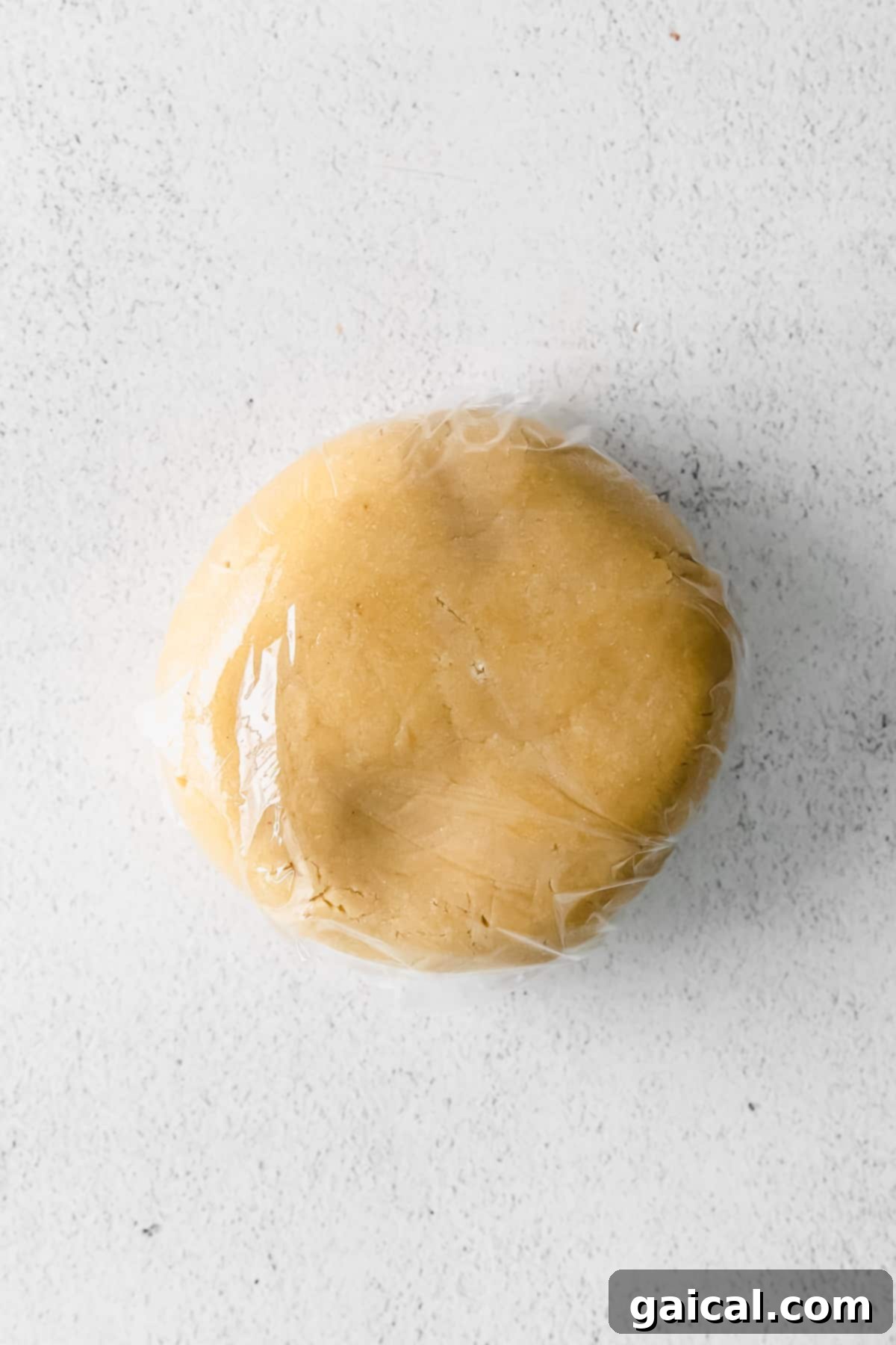 Chilling Almond Flour Sugar Cookie Dough Almond flour cookie dough wrapped tightly in plastic wrap, ready for chilling in the refrigerator.