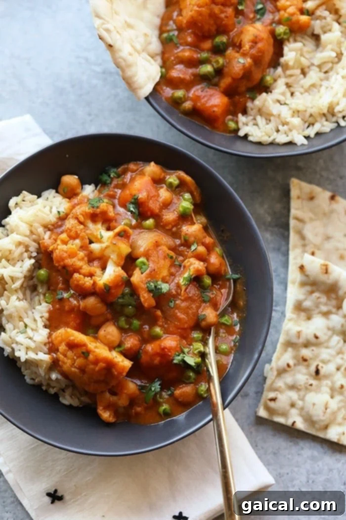 Delicious & Easy Cauliflower Tikka Masala Recipe Tikka masala in a bowl with naan on the side, highlighting its rich texture and color.