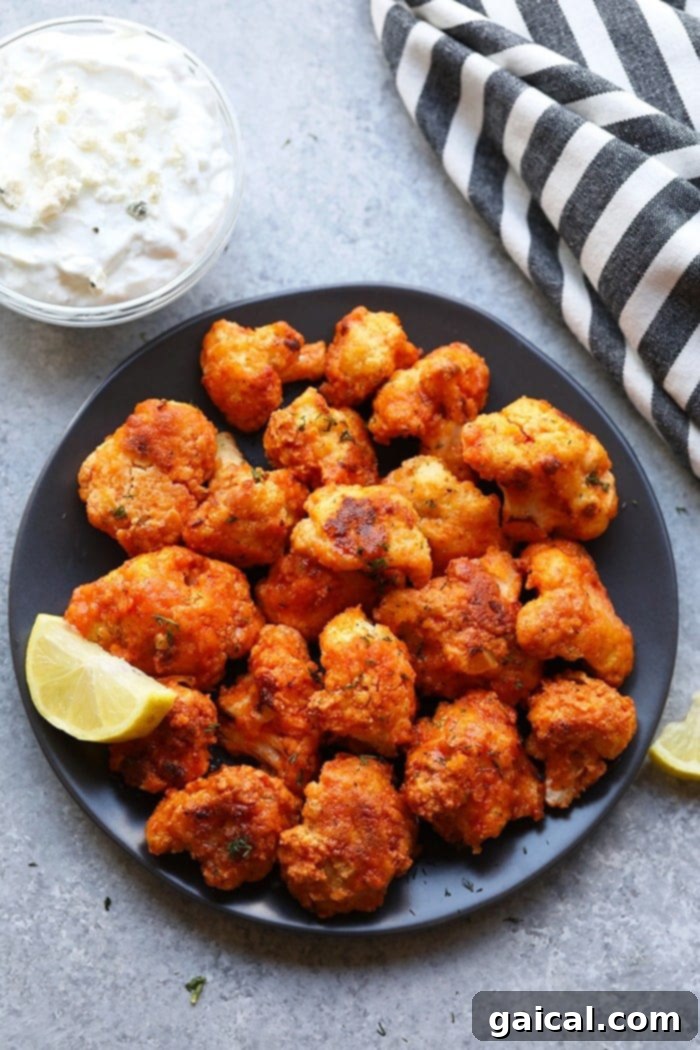Crispy Buffalo Cauliflower Bites 5 Serving of buffalo cauliflower wings on a white plate