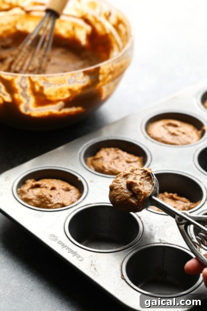 Perfectly Baked Gingerbread Muffins Freshly baked gingerbread muffins cooling on a wire rack, ready for glazing.
