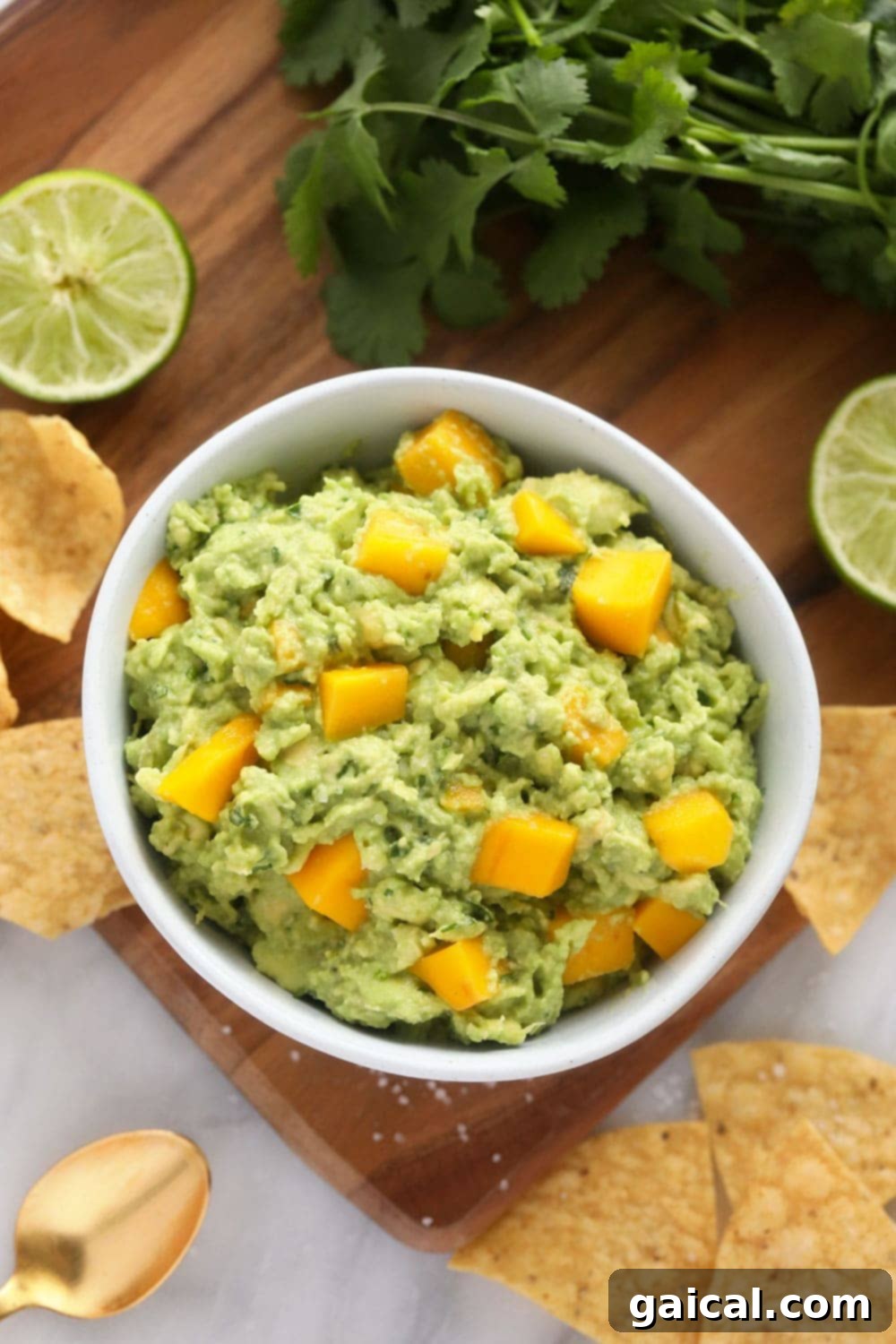 Fresh Mango Guacamole A bowl of vibrant mango guacamole, showcasing chunky mango pieces and fresh ingredients.