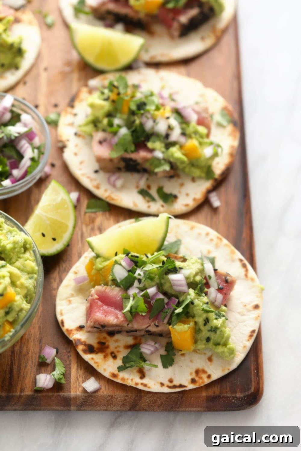 Ahi Tuna Tacos on Cutting Board Two vibrant ahi tuna tacos arranged on a wooden cutting board, ready to be enjoyed.