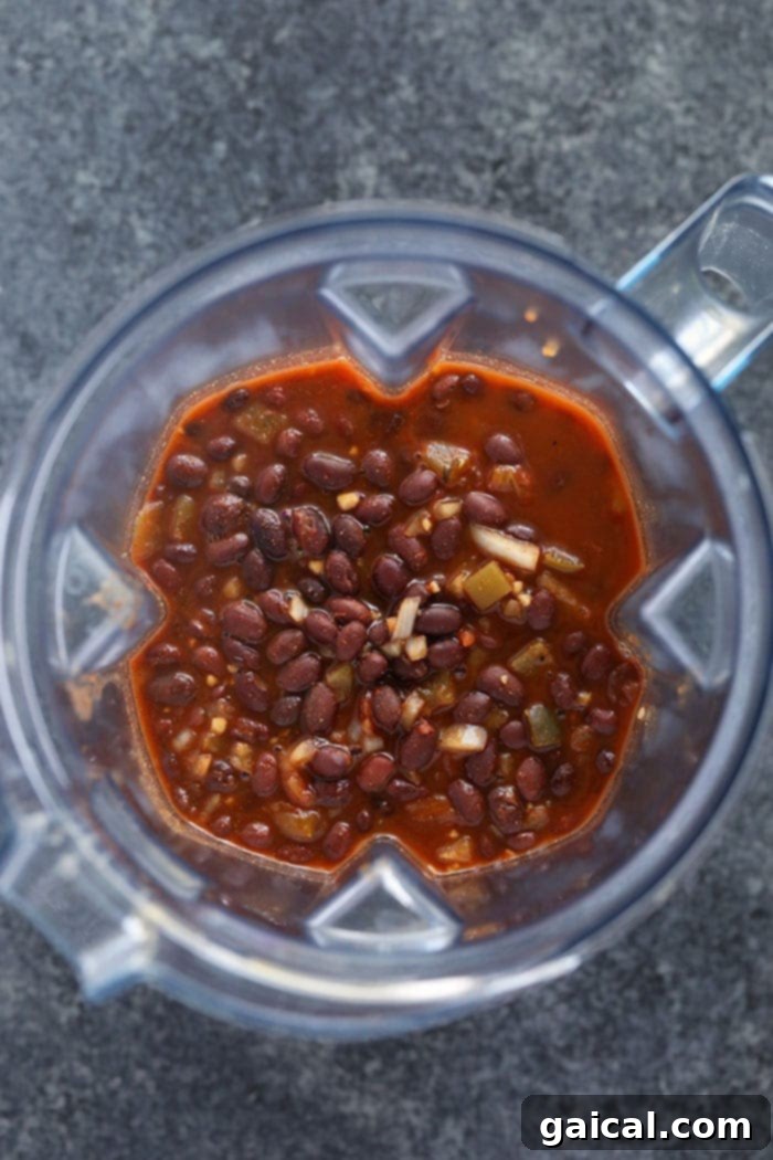 Blending Black Bean Soup Close-up of crock pot black bean soup being blended in a high-speed blender for a smooth and creamy consistency.