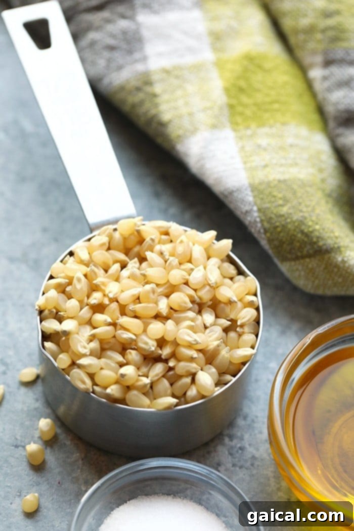 The simple ingredients for homemade popcorn Stovetop popcorn ingredients including kernels, oil, and salt in small bowls