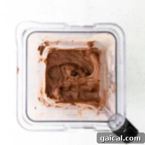 The smoothly blended chocolate protein ice cream mixture inside a blender, showcasing its perfect creamy consistency.