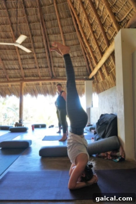 Nicaragua is the perfect location for a beach yoga adventure! A person expertly performing a headstand on a tranquil beach, highlighting Nicaragua as an ideal location for beach yoga adventures.