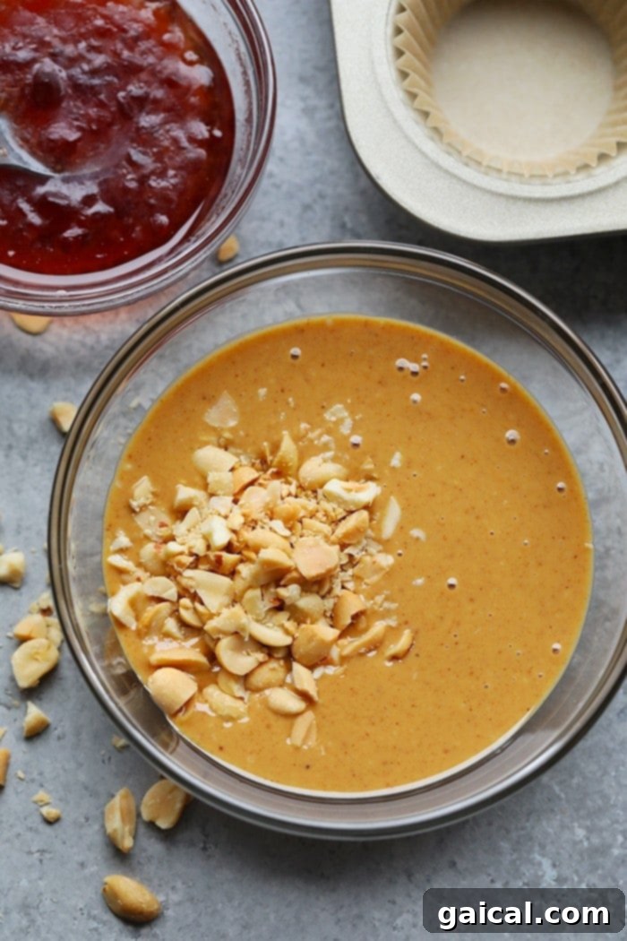 Prepping the Peanut Butter Layer for Fat Bombs A bowl of creamy and crunchy peanut butter and jelly fat bomb batter, ready for chilling.