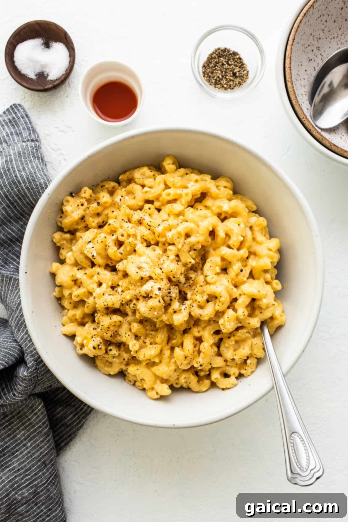 Protein-Powered Instant Pot Mac 2 A serving bowl filled with creamy, golden Instant Pot Protein Mac and Cheese, garnished with fresh herbs, ready to be enjoyed.