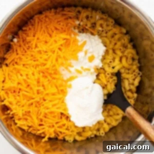 Cheese and noodles mixing in Instant Pot, turning creamy.