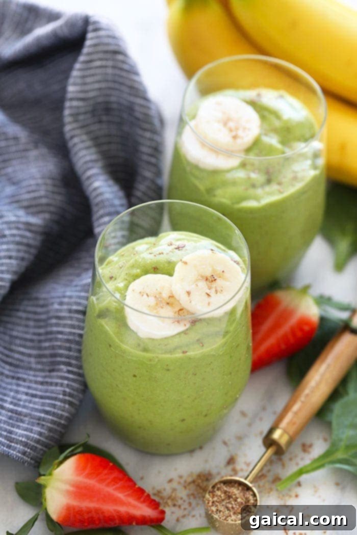 Refreshing Vegan Green Smoothie with Strawberries A vibrant green smoothie in a glass, garnished with fresh strawberries, illustrating a healthy and delicious vegan breakfast drink.