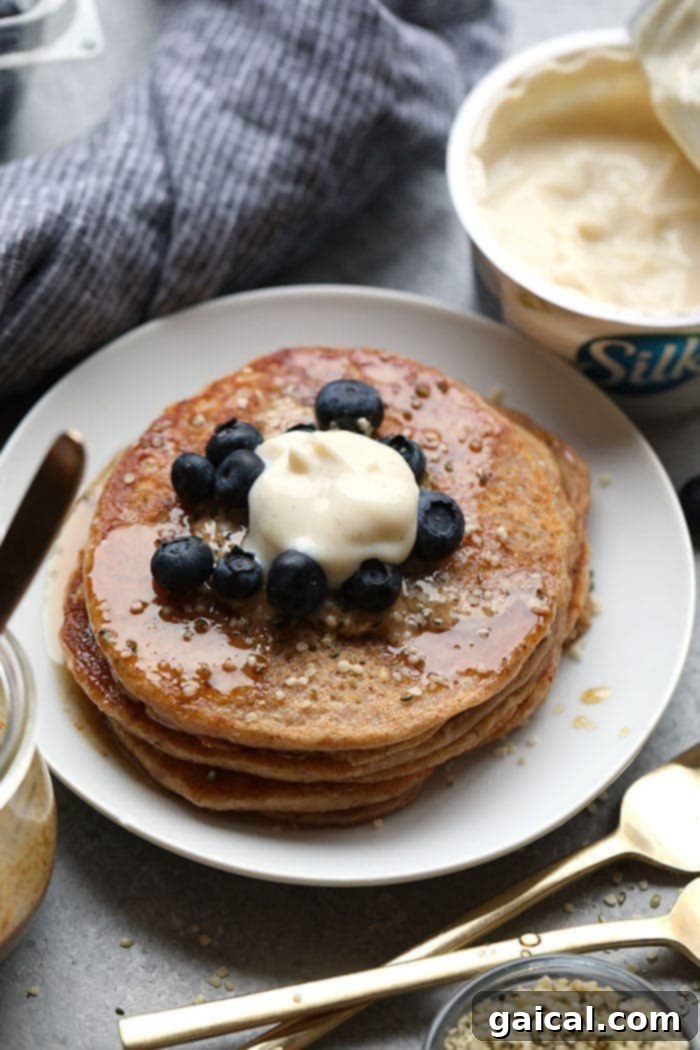 Vegan Banana Pancakes: Fluffy & Dairy-Free A stack of golden vegan banana pancakes on a plate, adorned with fresh berries and a drizzle of syrup, ready for a delightful breakfast.