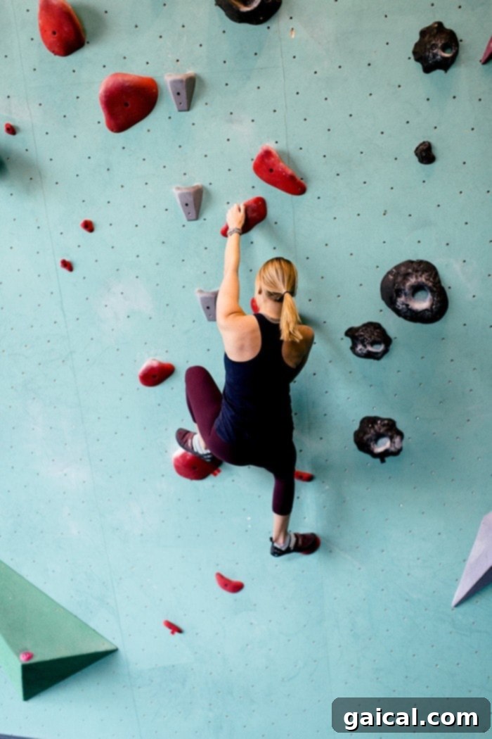 Lee climbing with focus and determination on a bouldering wall, showcasing the physical challenge of the sport.