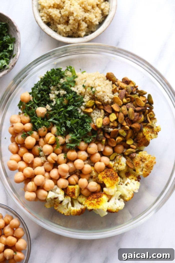Assorted healthy golden roasted cauliflower salad ingredients in a large mixing bowl, ready for tossing.