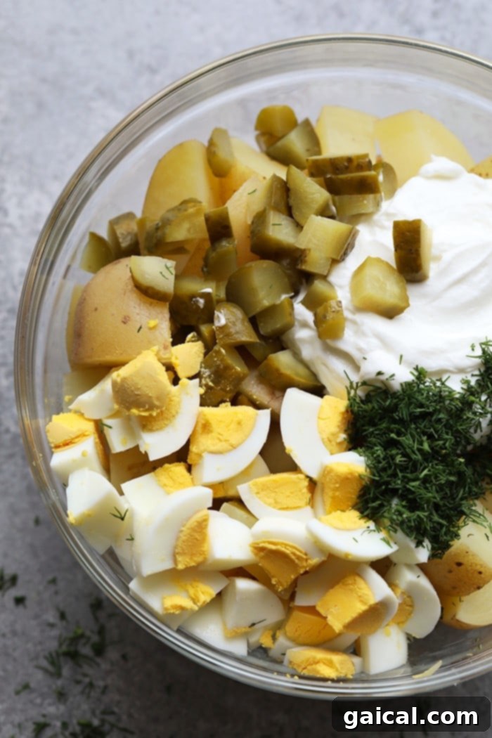 A perfectly mixed bowl of Instant Pot Potato Salad with Greek yogurt. All the delicious ingredients for the Instant Pot Potato Salad mixed together in a large bowl, ready to serve.