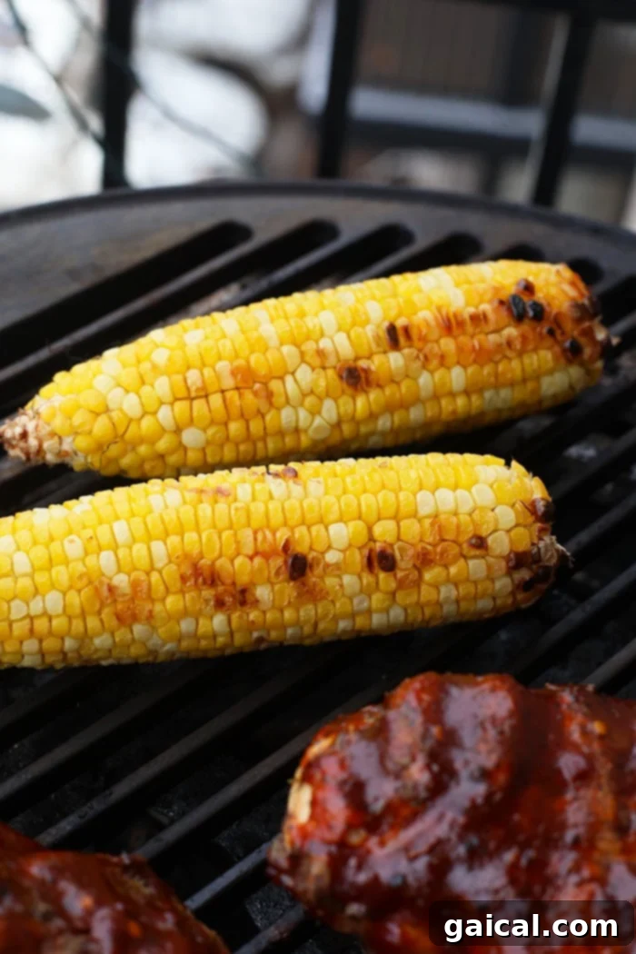 Start up your grill and start prepping these bbq chicken bowls for dinner tonight! They are ready in under an hour and the whole family will love them! Chicken breasts and corn on the cob grilling together on an outdoor barbecue, creating perfect char marks and a delicious smoky aroma.