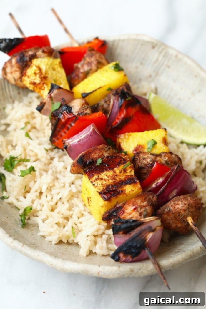 Vibrant Grilled Pineapple and Jerk Chicken Kebabs ready to be served, showcasing juicy chicken, golden pineapple, and colorful vegetables on skewers.